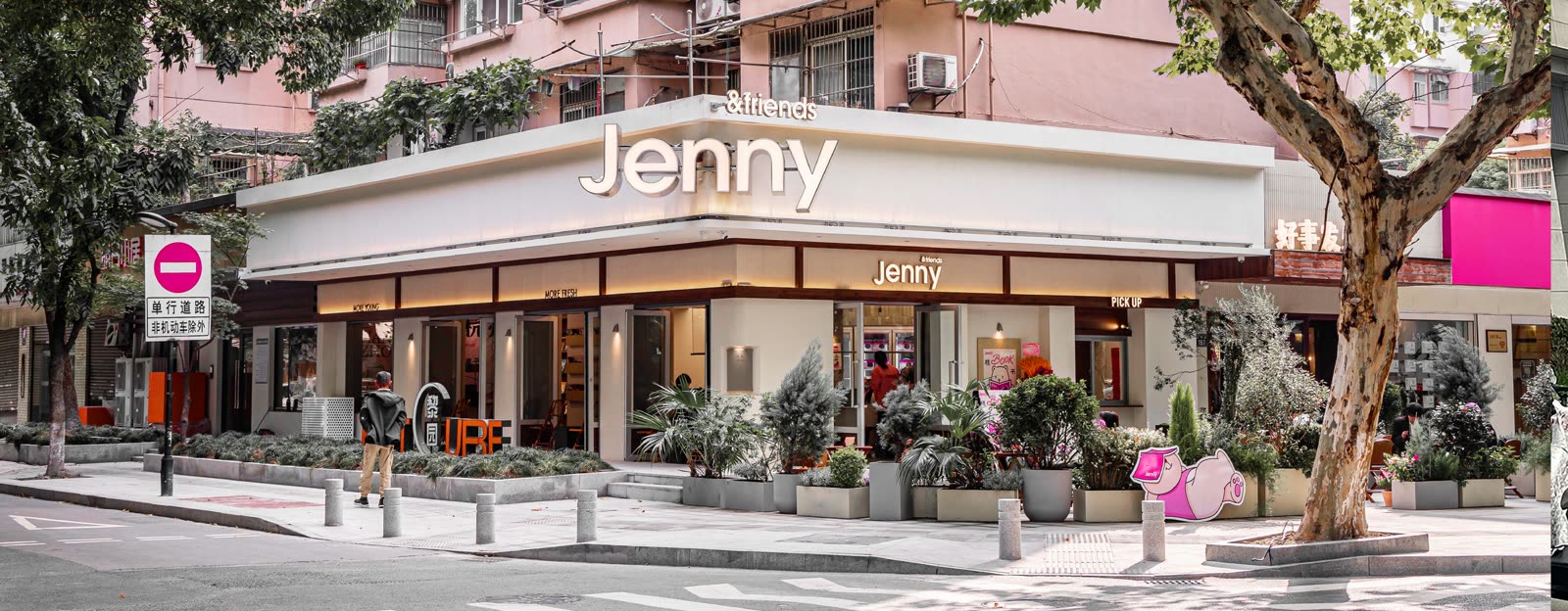 街角店的外观：白色檐口上写着 Jenny & friends，门口有一棵很大的法国梧桐。